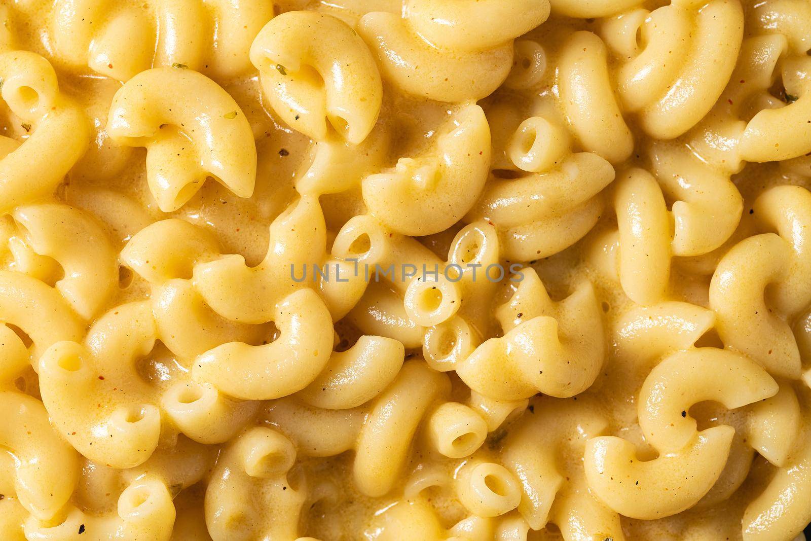 Delicious Mac n Cheese or macaroni and cheese on a black porcelain plate by Sonat