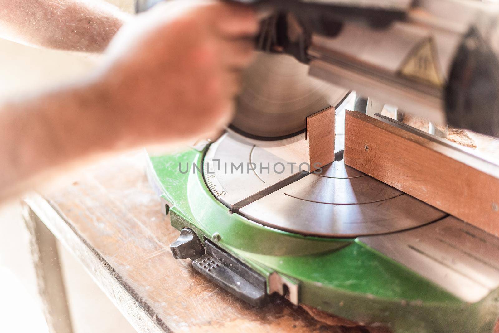 miter saw in motion, blurred hand in foreground by ivanmoreno
