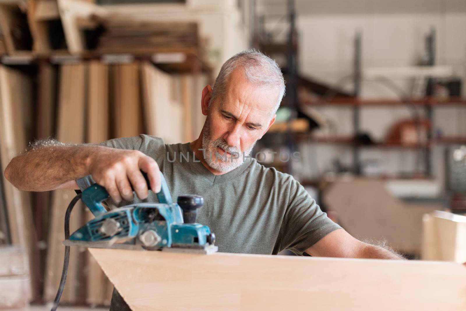 Man planing wood with a hand planer, front view