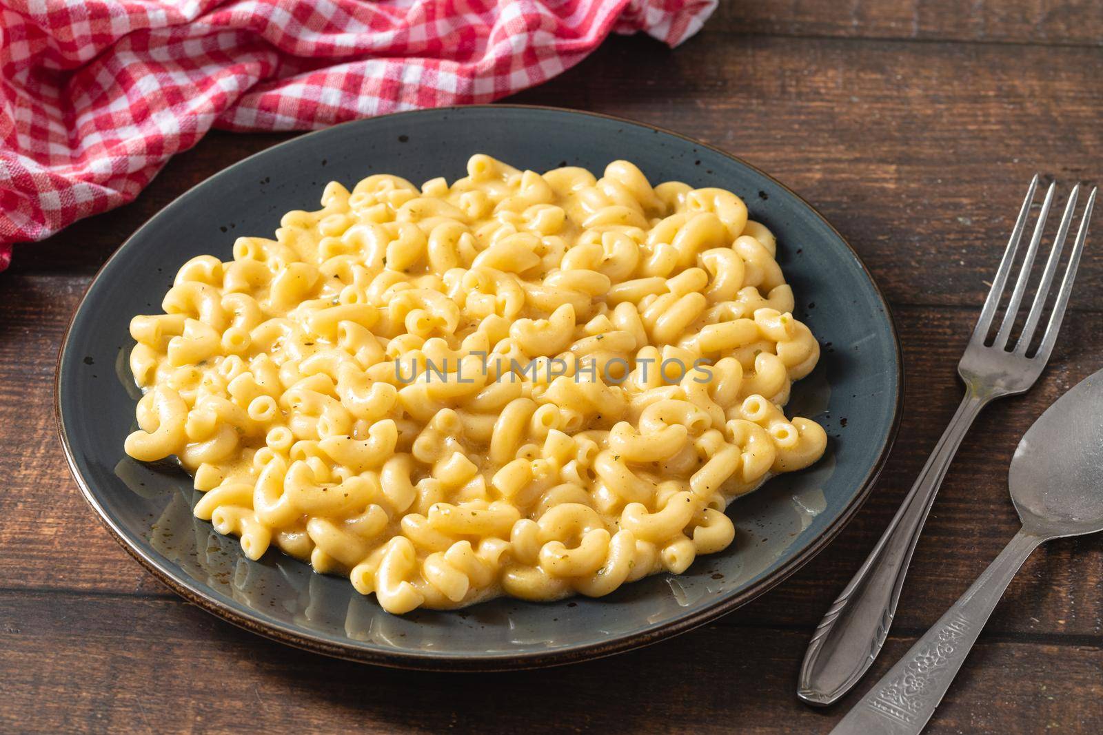 Delicious Mac n Cheese or macaroni and cheese on a black porcelain plate by Sonat