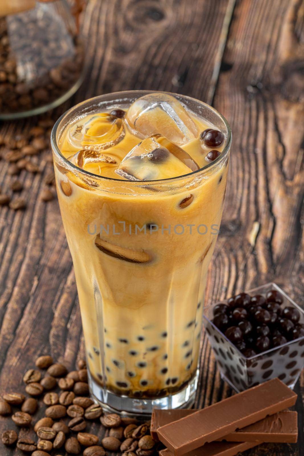 Bubble tea with coffee and chocolate in glass cup on dark background. by Sonat
