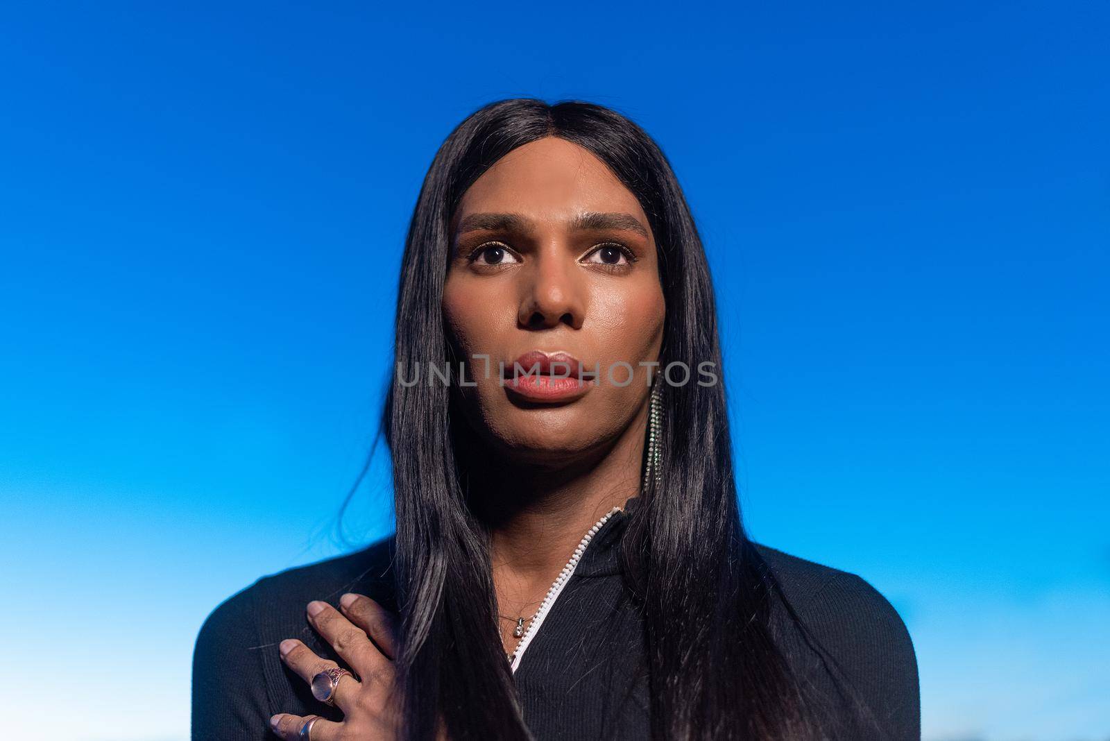 Close up portrait of a transgender black woman looking to the horizon during sunset outdoors