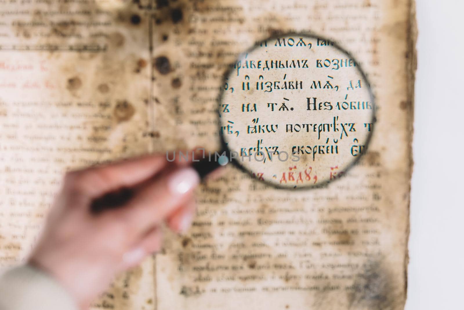 Woman researcher explores antique book with magnifier. Scientific translation of literature. Investigating manuscript with ancient writings by kristina_kokhanova