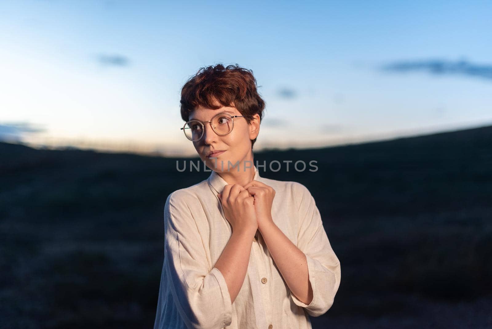 Portrait with copy space at dusk of a non-binary gender woman looking at the side outdoors