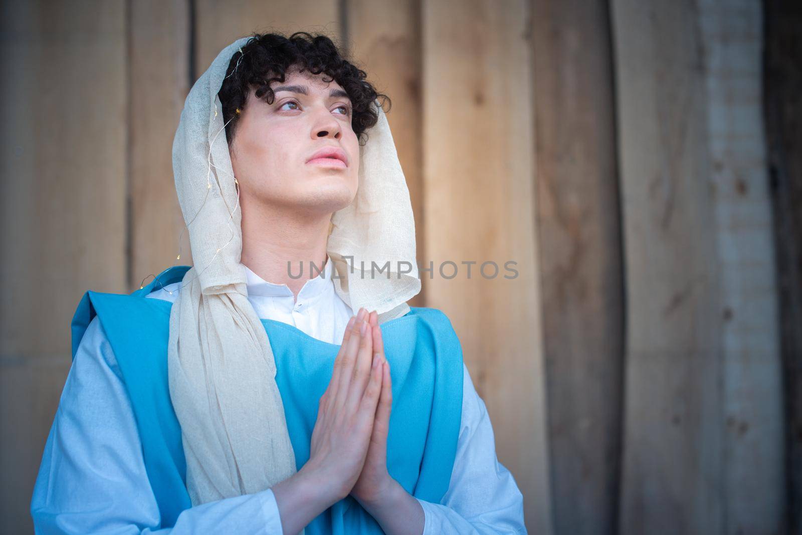 Portrait of an androgynous virgin mary praying while looking up by ivanmoreno