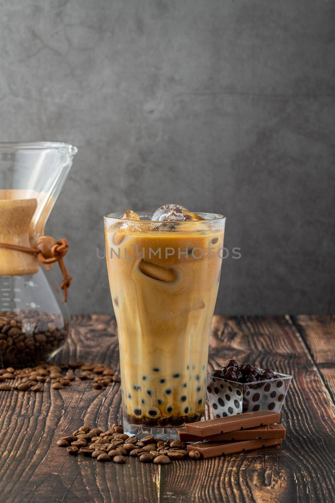 Bubble tea with coffee and chocolate in glass cup on dark background.