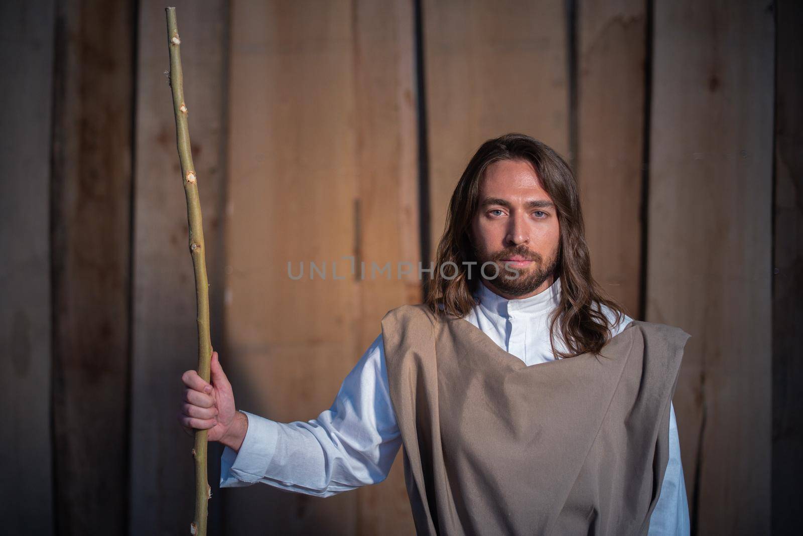 Portrait with close up view of the biblical character of Joseph in a crib while holding a stick