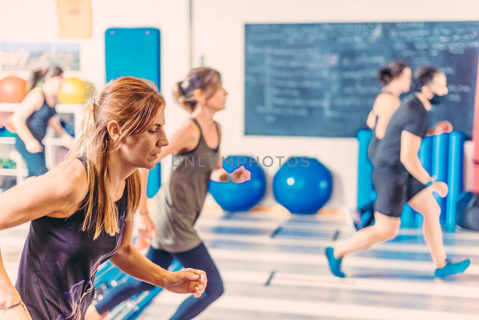 Side view of women doing aerobic exercises in health club. Concept of health club.