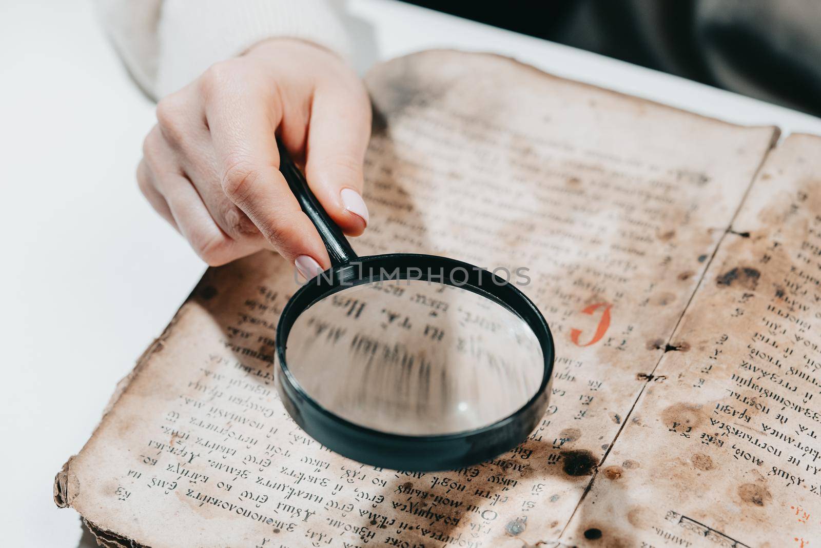 Historian scientist reading antique book with magnifying glass. Translation of religious literature. Manuscript with ancient writings. Treasures of the past. Museum piece. by kristina_kokhanova