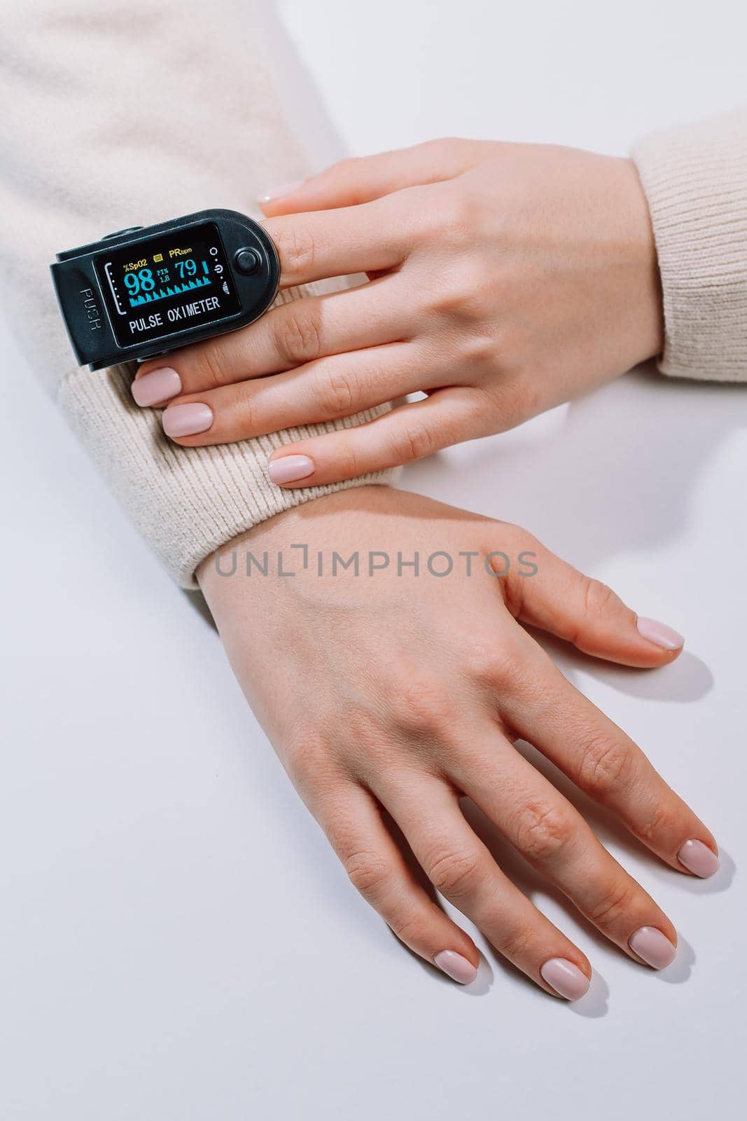 Woman put on pulse oximeter on finger, check blood oxygen saturation. Monitoring heart rate at home during pandemic coronavirus covid-19. High quality