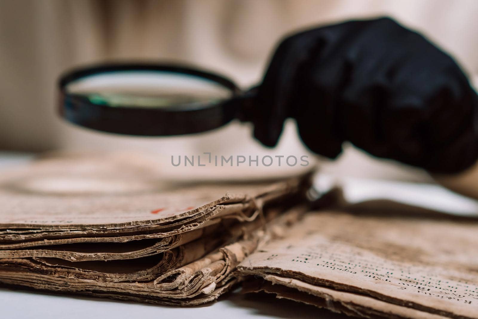 Historian scientist in gloves reading antique book with magnifying glass. Translation of religious literature. Manuscript with ancient writings. Treasures of the past. Museum piece. High quality
