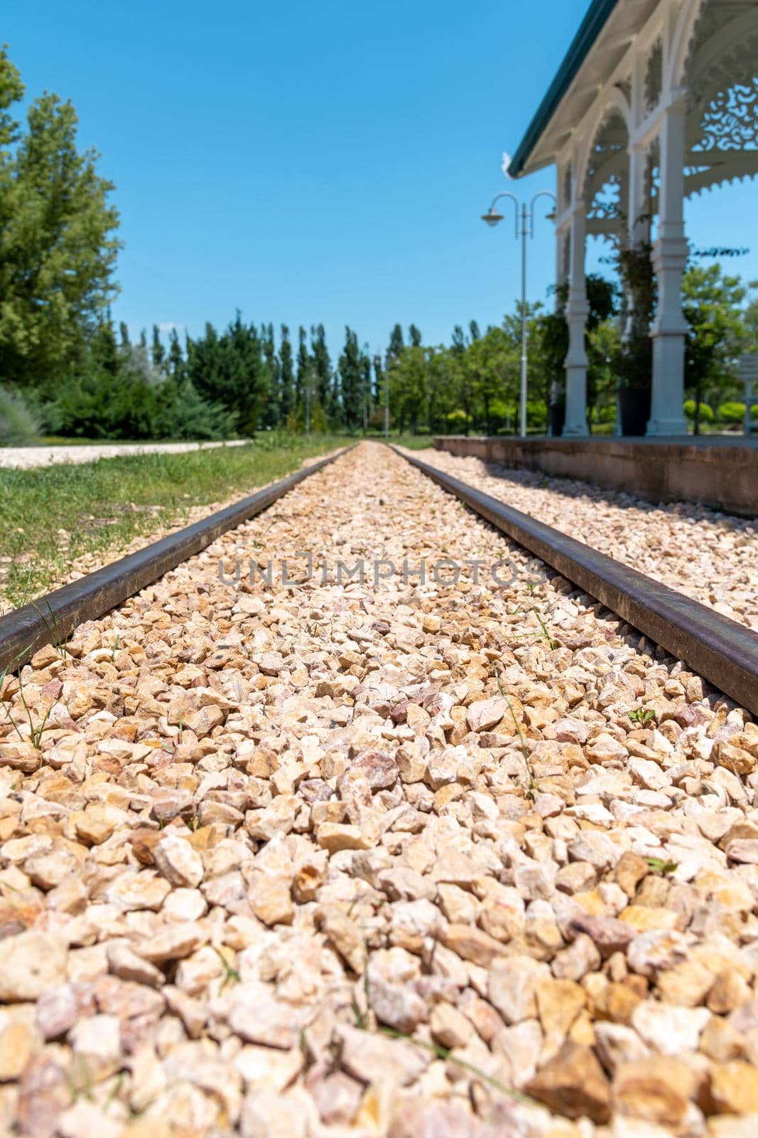 Railway tracks in front of the railway station on a sunny day at horizontal angle by Sonat
