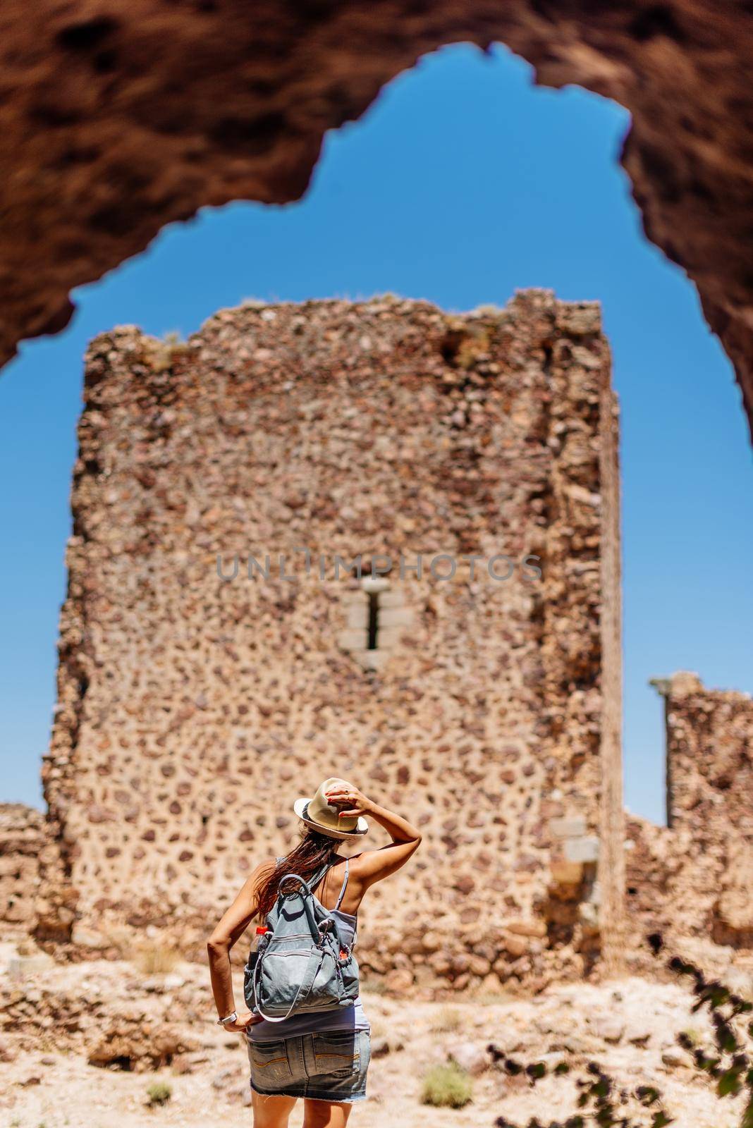 Tourist looking at the wall of a medieval castle. by ivanmoreno