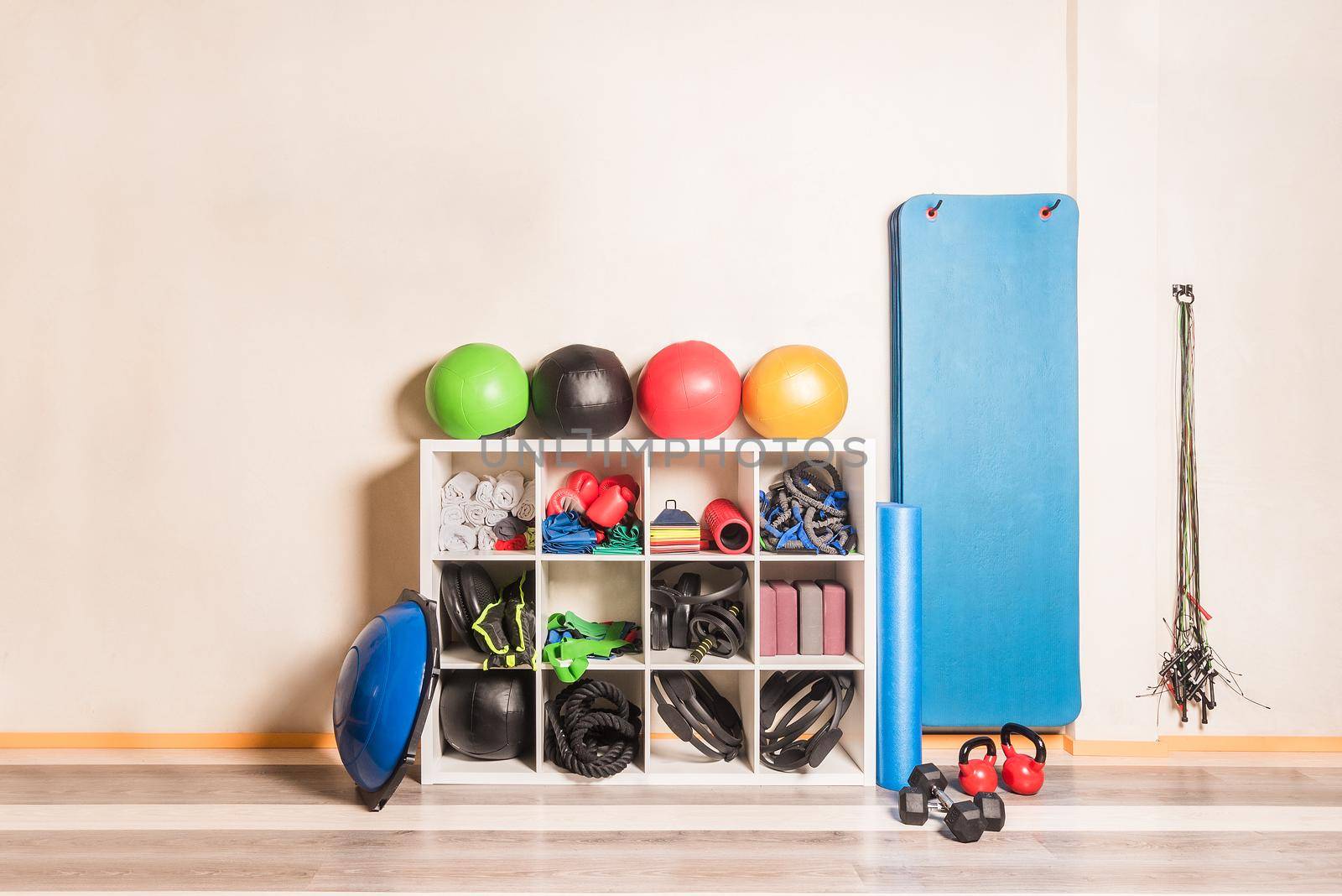 Front view of gym equipment arranged on shelves on wall by ivanmoreno