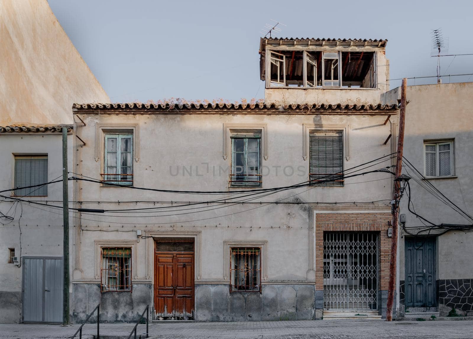 Views of the facade of an abandoned white rural house in Consuegra, Spain