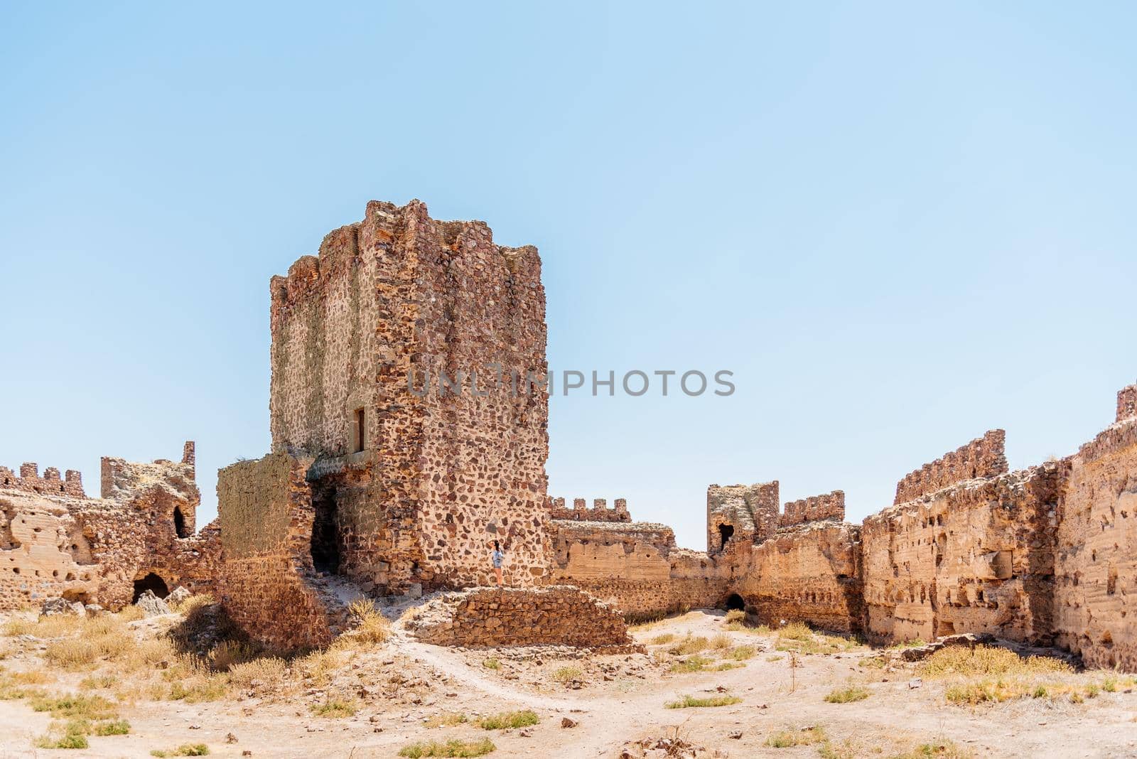 Restored tower in the middle of a ruined medieval castle in a sunny day. Almonacid Castle, in Spain