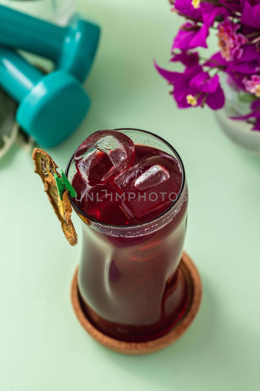 Refreshing healthy drink in long glass cup on light green background by Sonat