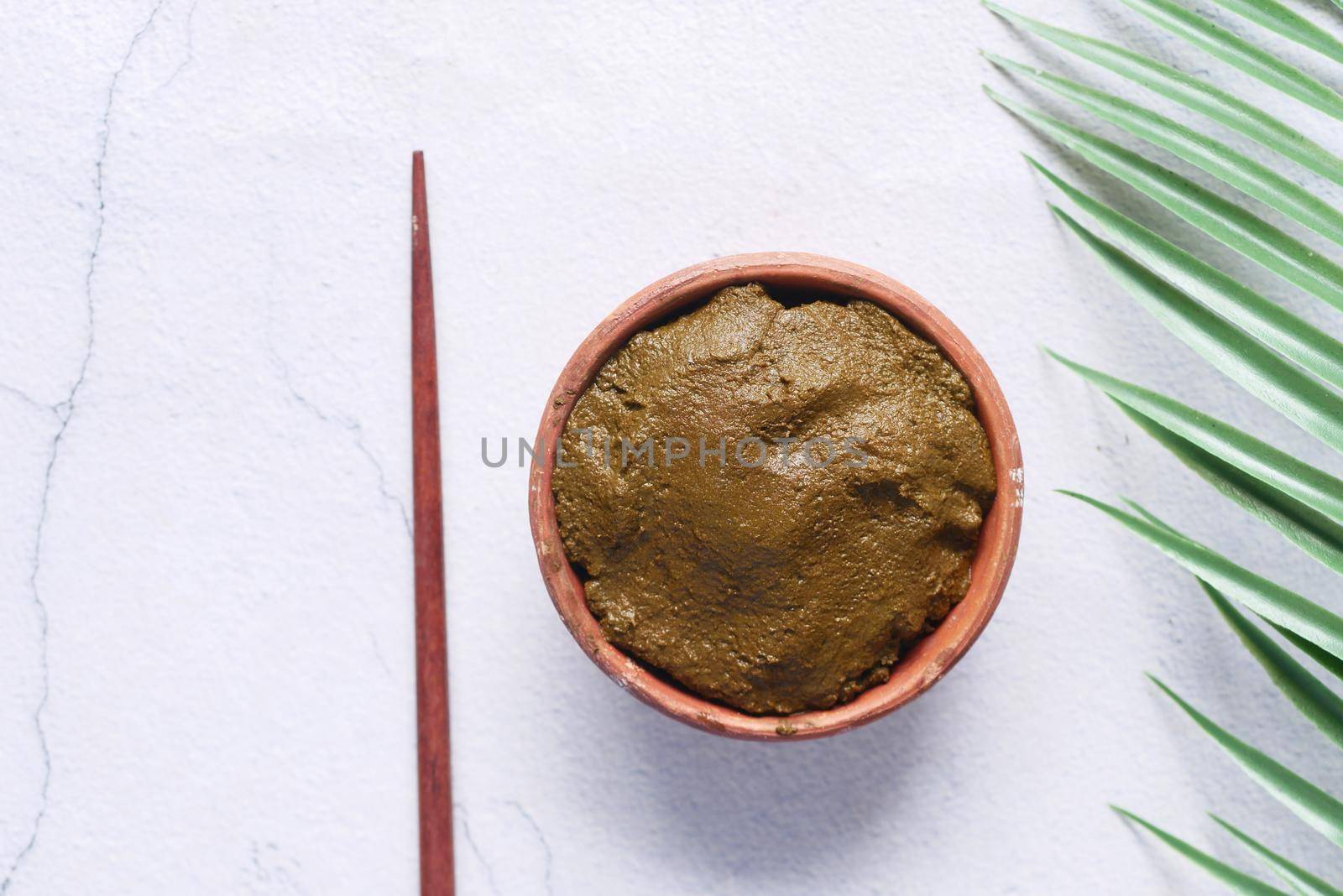 The wooden bowl with rehydrated henna on table .