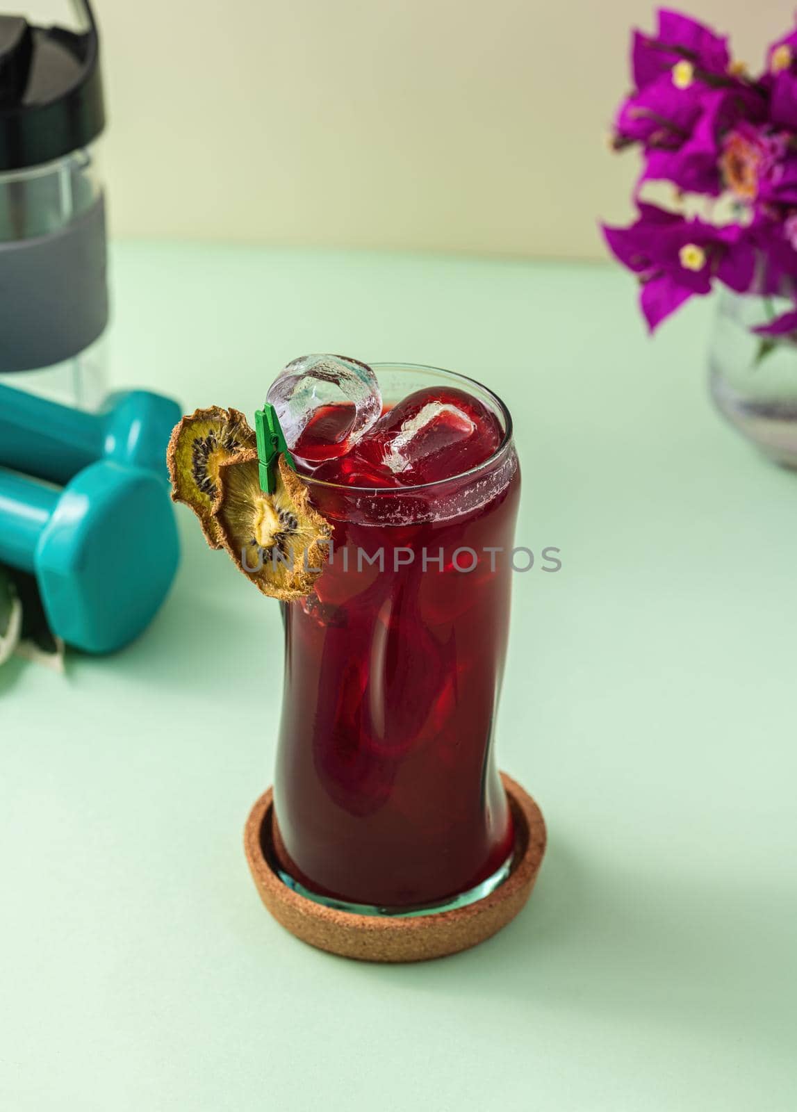 Refreshing healthy drink in long glass cup on light green background