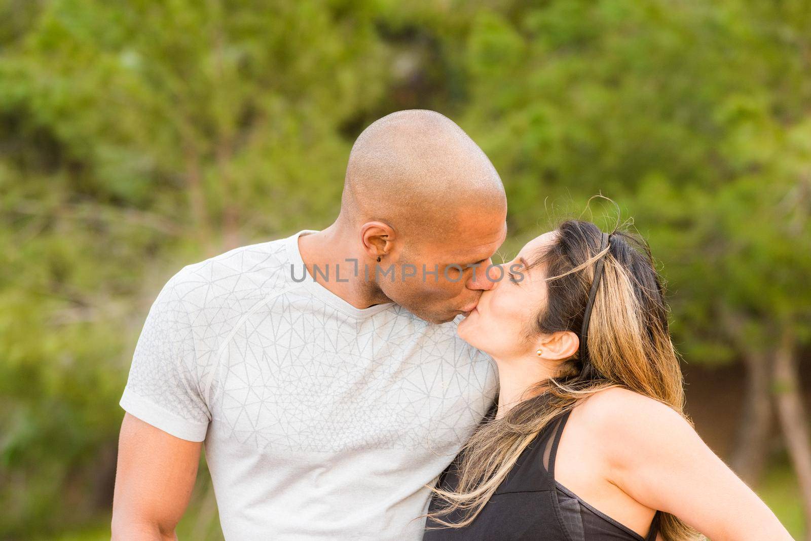 Portrait of fitness couple hugging and kissing by ivanmoreno