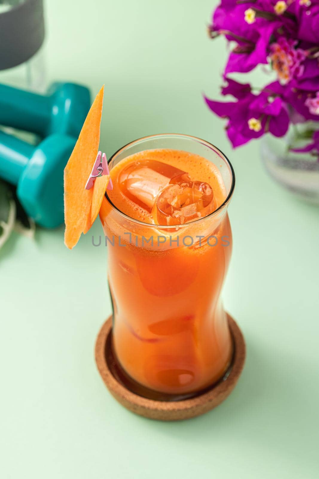 Refreshing healthy drink in long glass cup on light green background