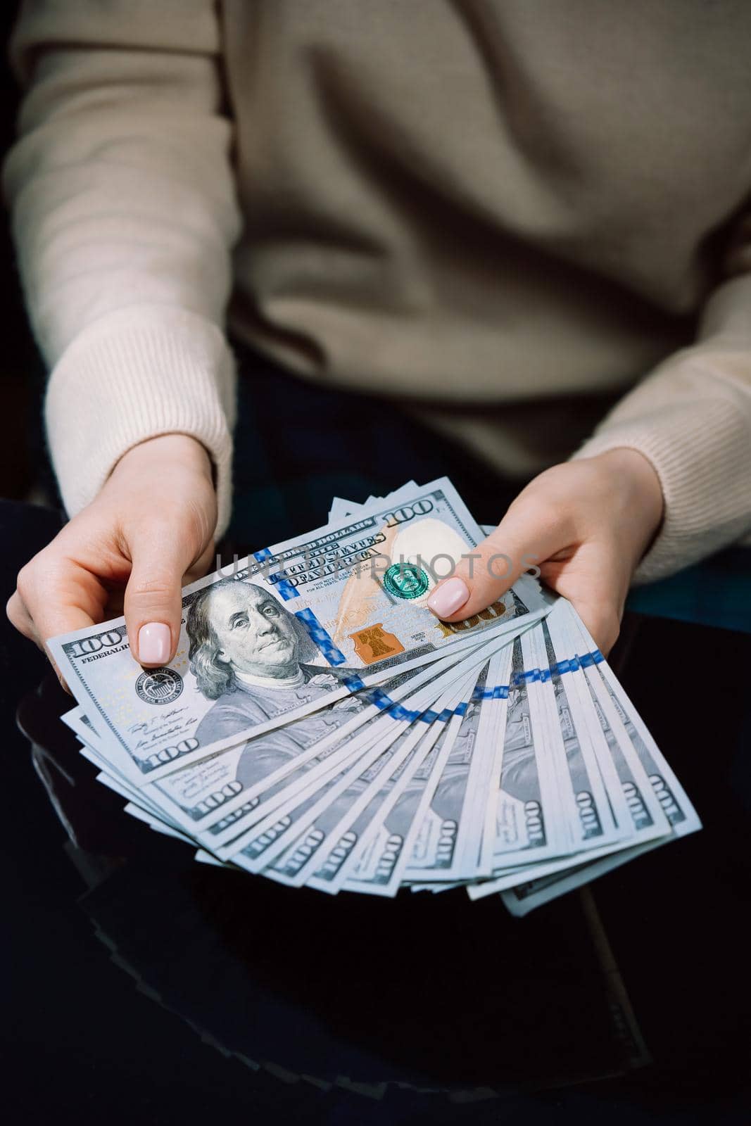 Woman is counting cash money - salary or other income. Close-up of hands with banknotes.