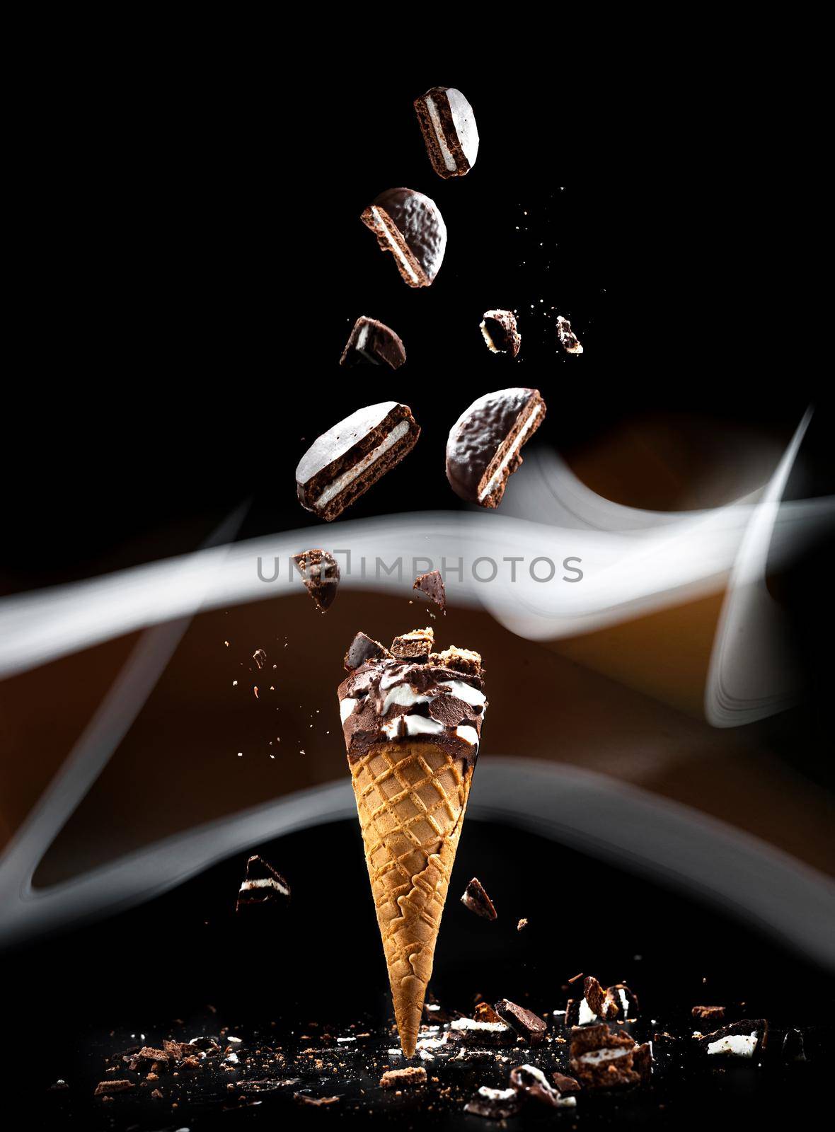 Cookies N' Cream ice cream on a black background in a waffle cup. Abstract light line on a black background. Food flying