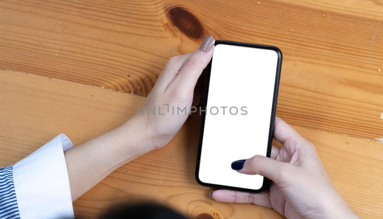 hand woman using a telephone, empty screen smart phone and computer on wooden table top view