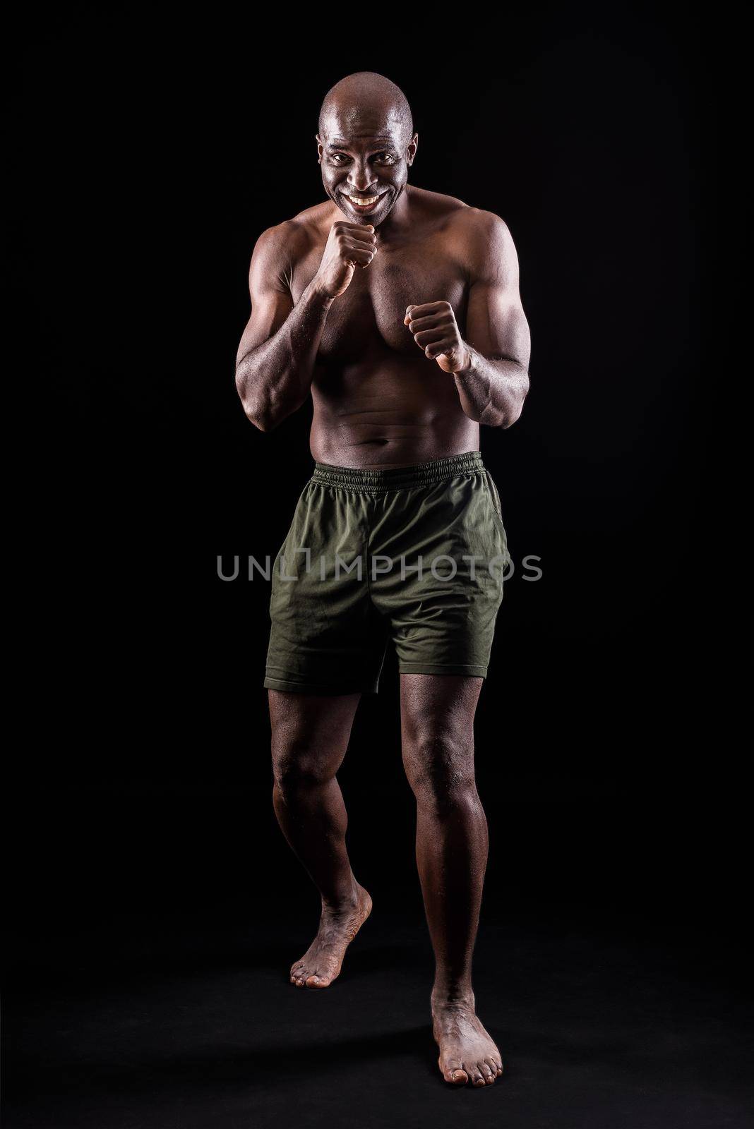 Muscular adult male smiling standing in defensive boxing pose by ivanmoreno