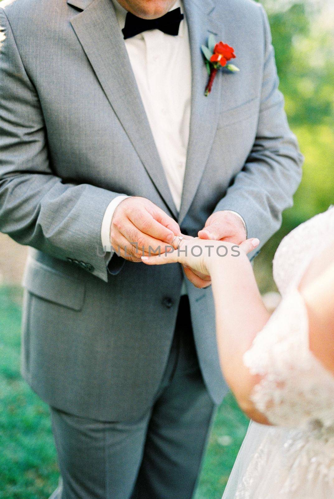Groom puts a ring on the bride finger. Close-up. High quality photo