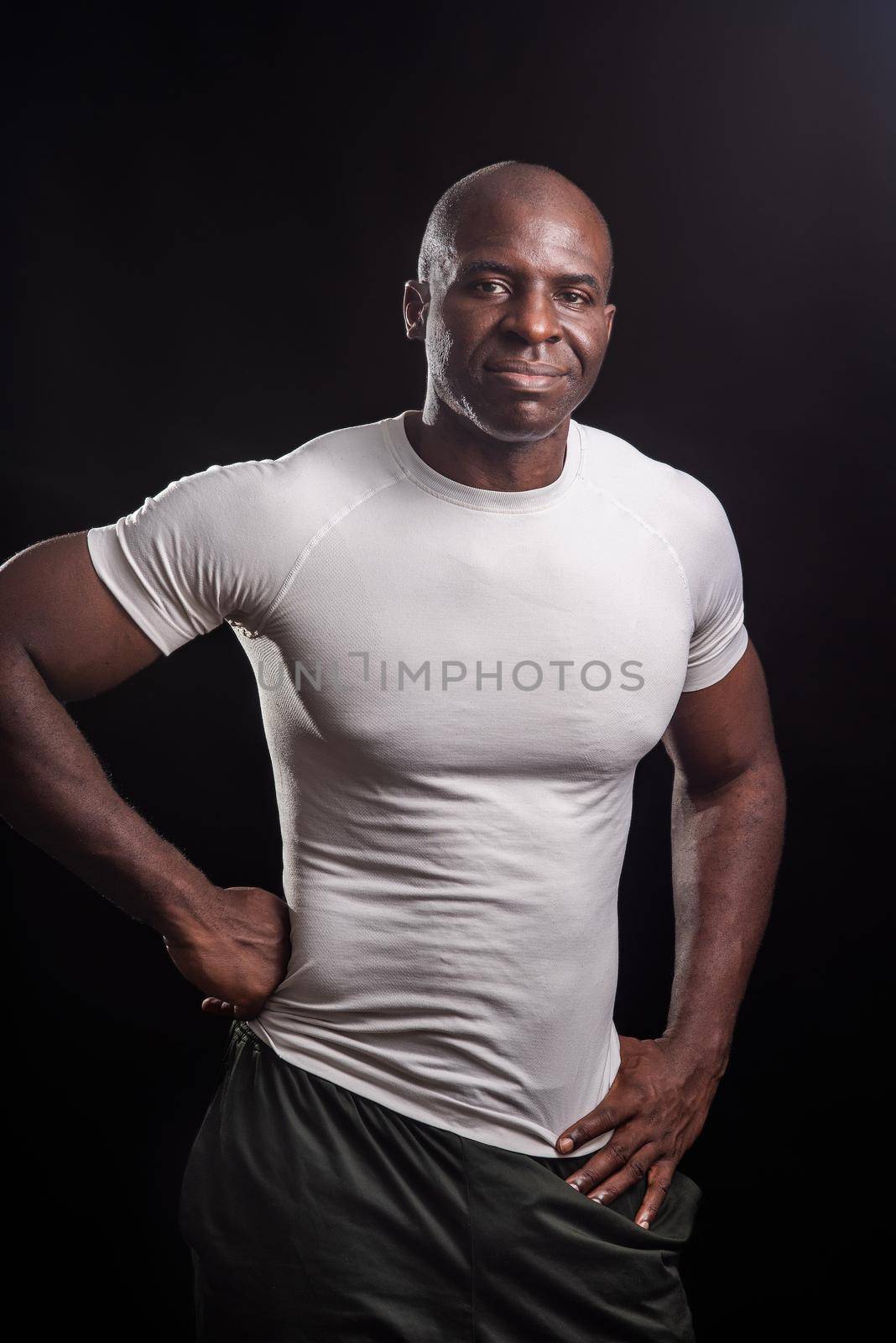 Portrait of an african american man standing looking at camera with hands on waist by ivanmoreno