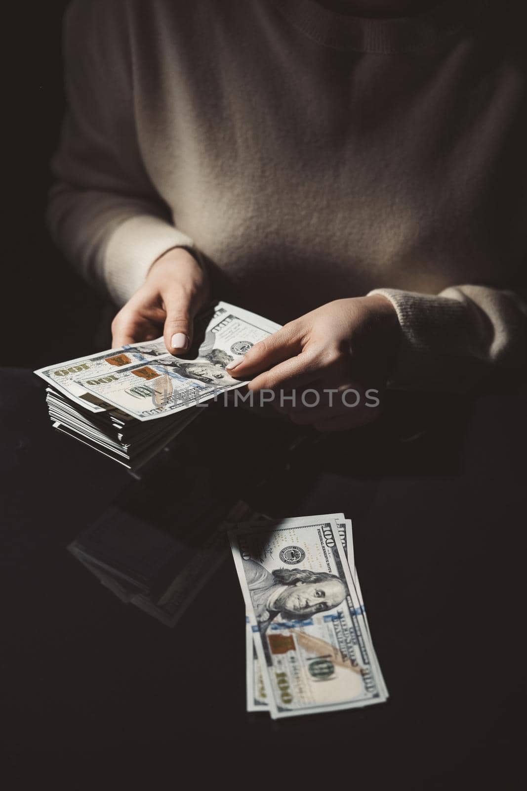 Woman is counting cash money - salary or other income. Close-up of hands with banknotes.