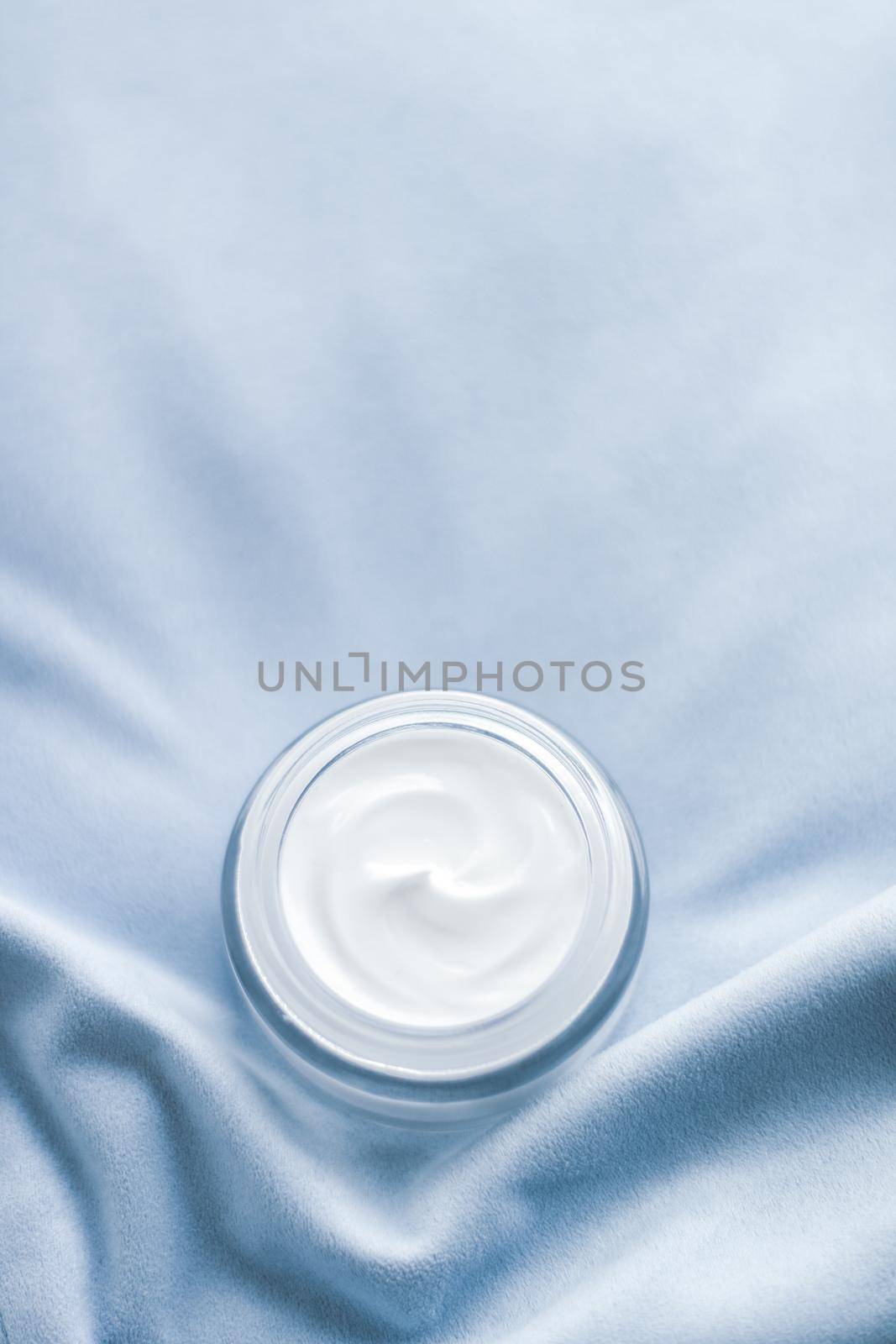 Luxury face cream jar on blue silk by Anneleven