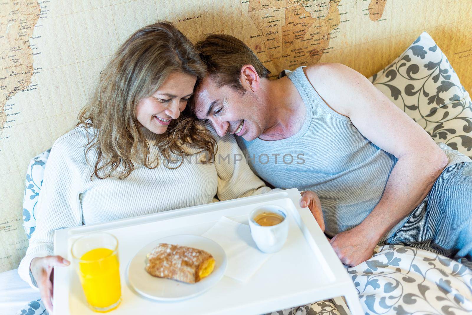 Mature couple in love in bed, with a tray with breakfast. High quality photo