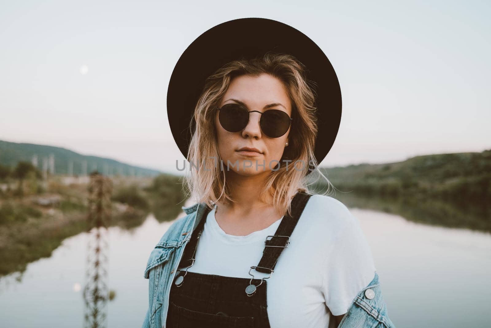 Young trendy hipster woman in black hat and dungaree. High quality photo