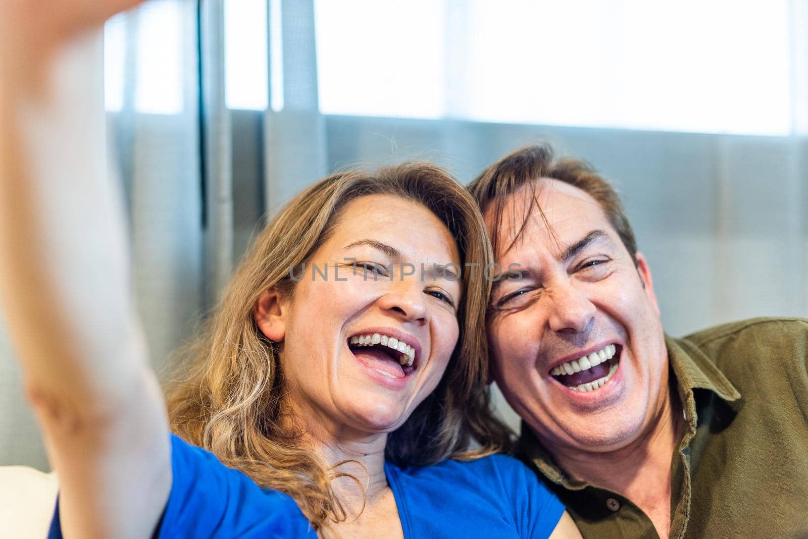 Smiling mature man and woman taking a selfie. by ivanmoreno