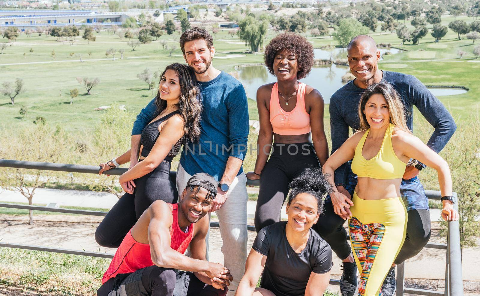 Group portrait of runners smiling at camera. Horizontal framing.