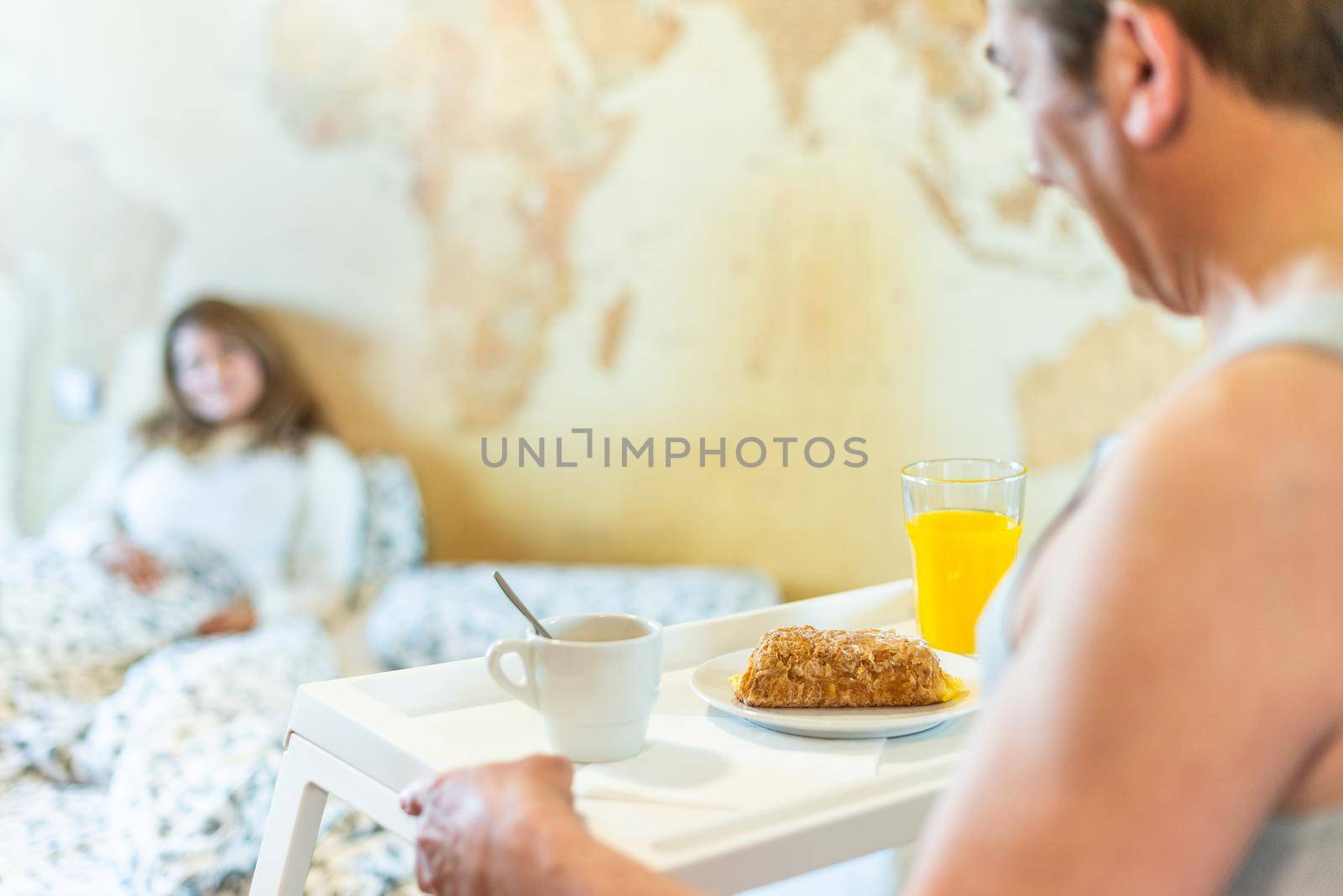 Mature man in love bringing his wife breakfast in bed on a tray. by ivanmoreno