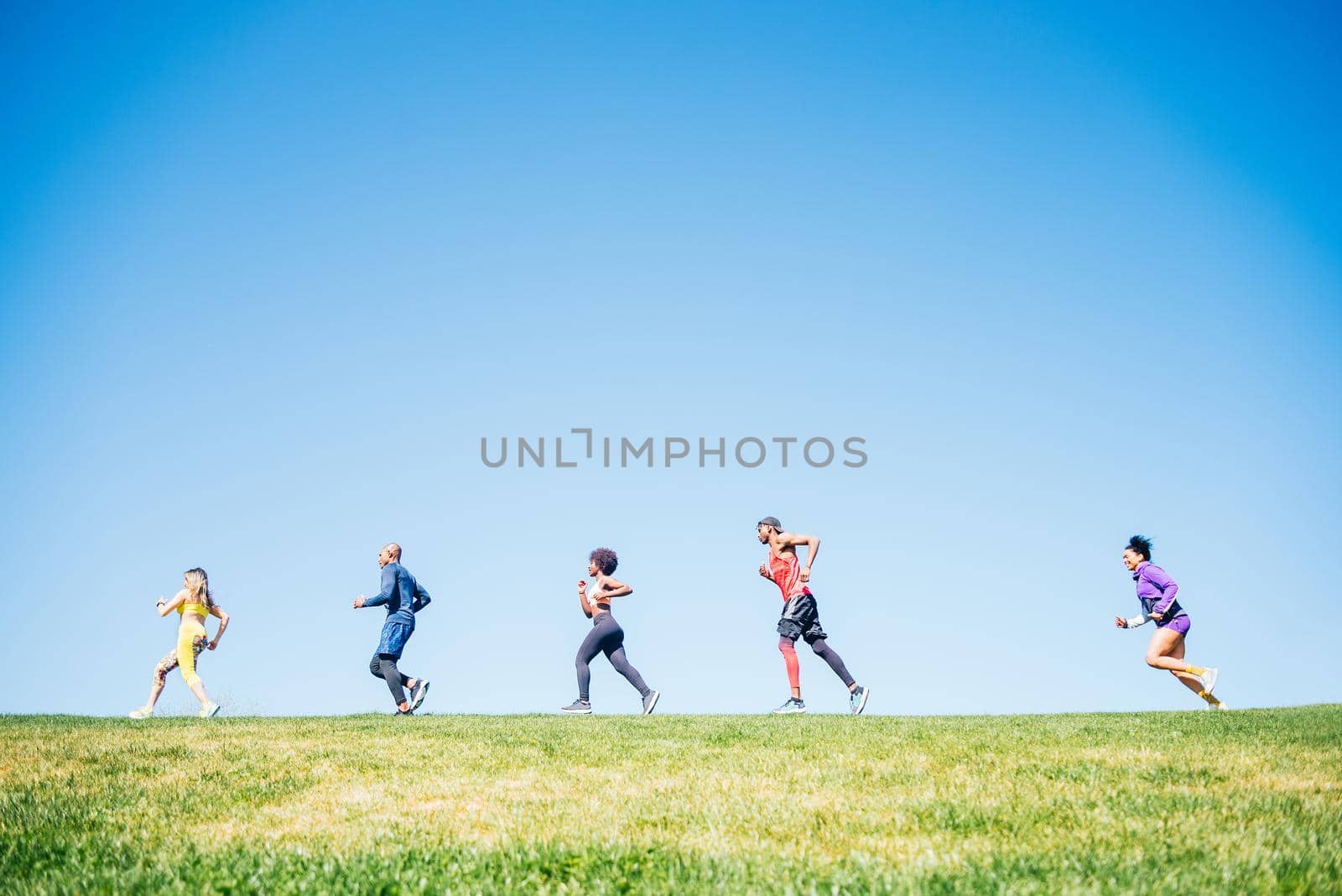 Group of runners training in a park. Side view.