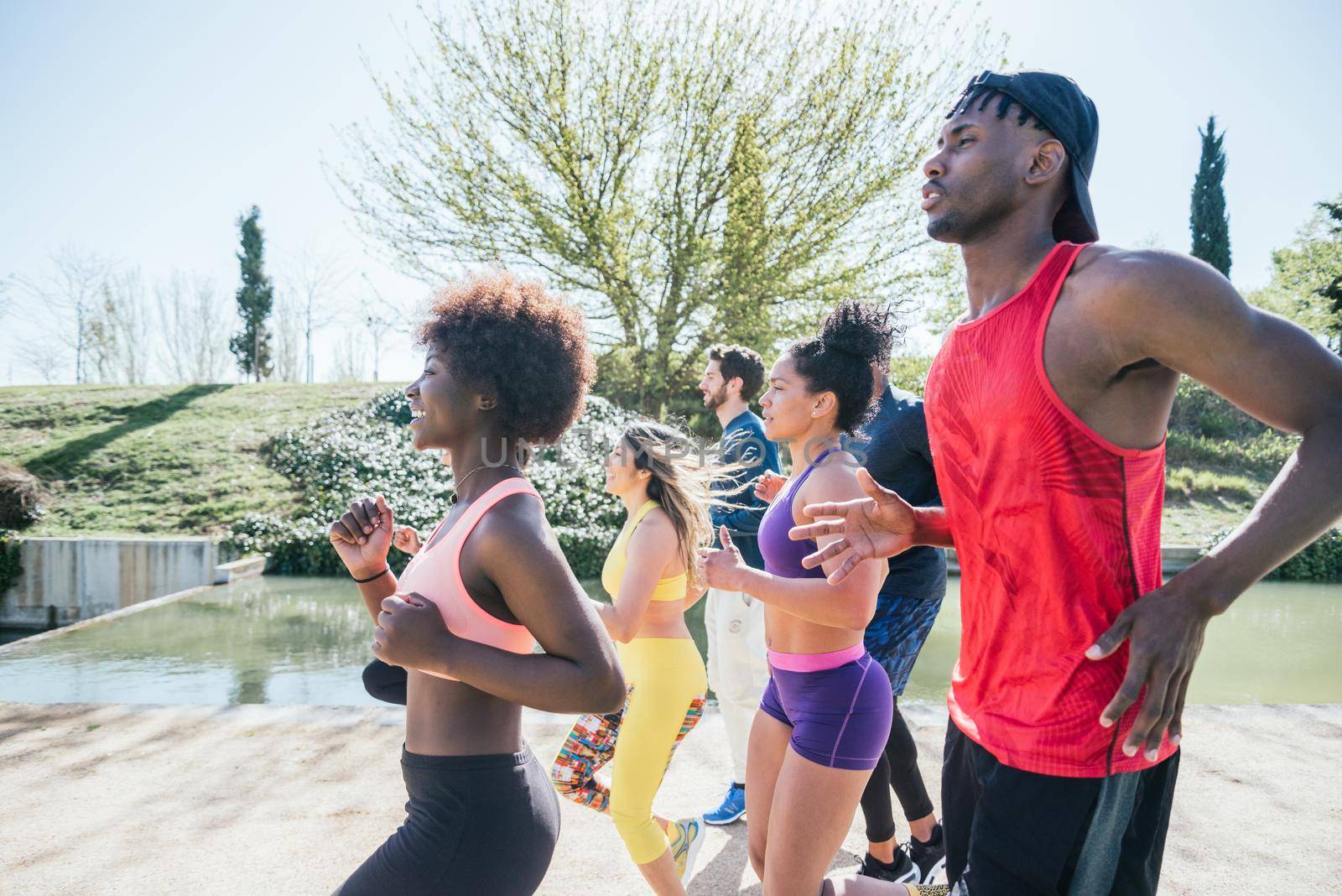 Group of runners training in a park. Side view.