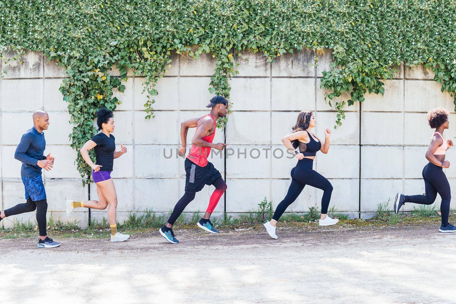 Group of runners training in a park. Side view.