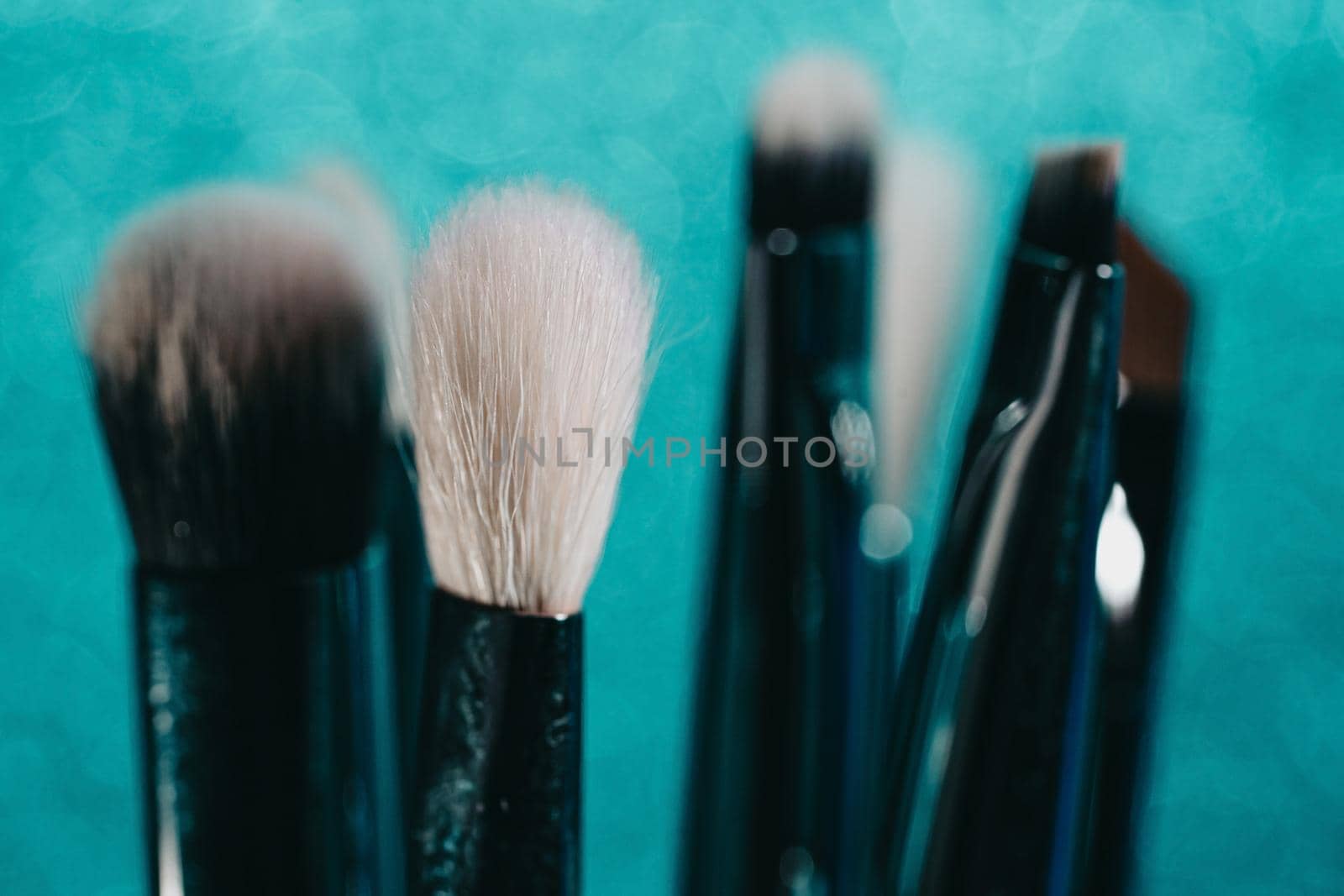 Cosmetics make-up brushes on blue sparkling background. High quality photo