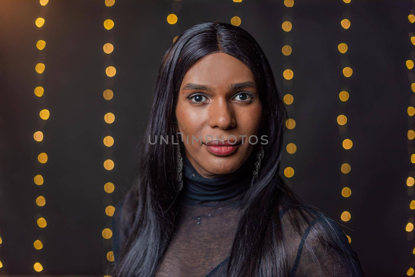 Portrait of a transgender person looking at camera with a blurred light background with copy space