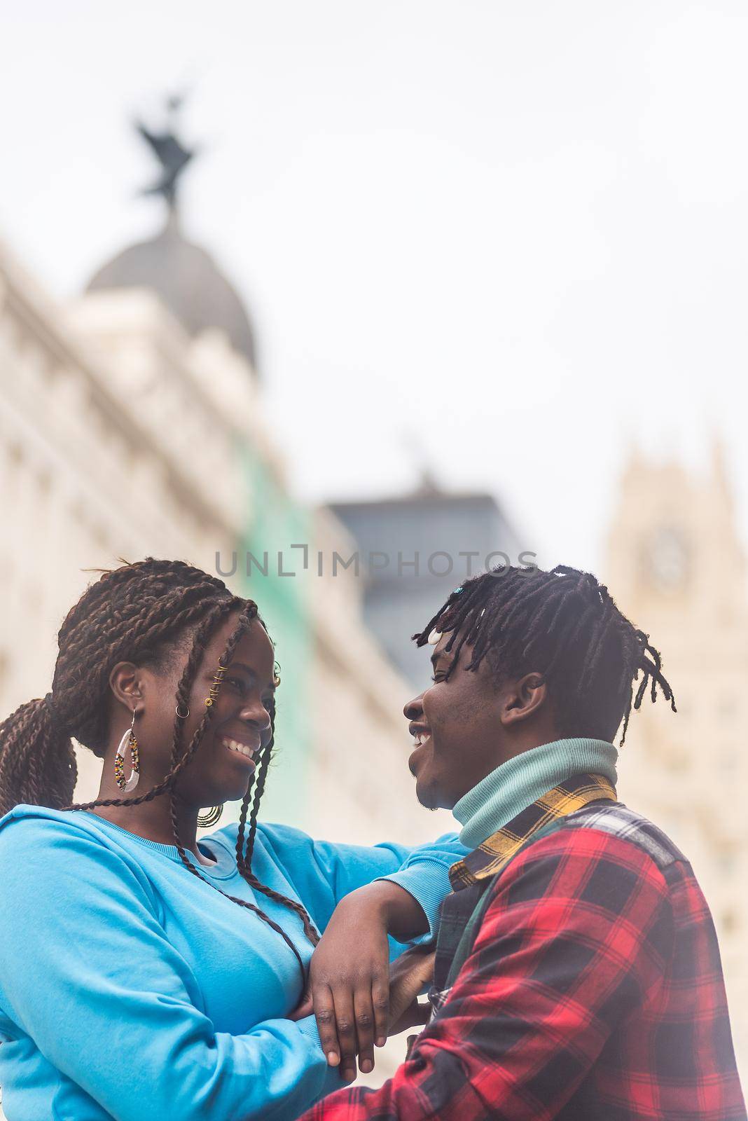 Black couple in love, in the city. Looking at each other. Selective focus.