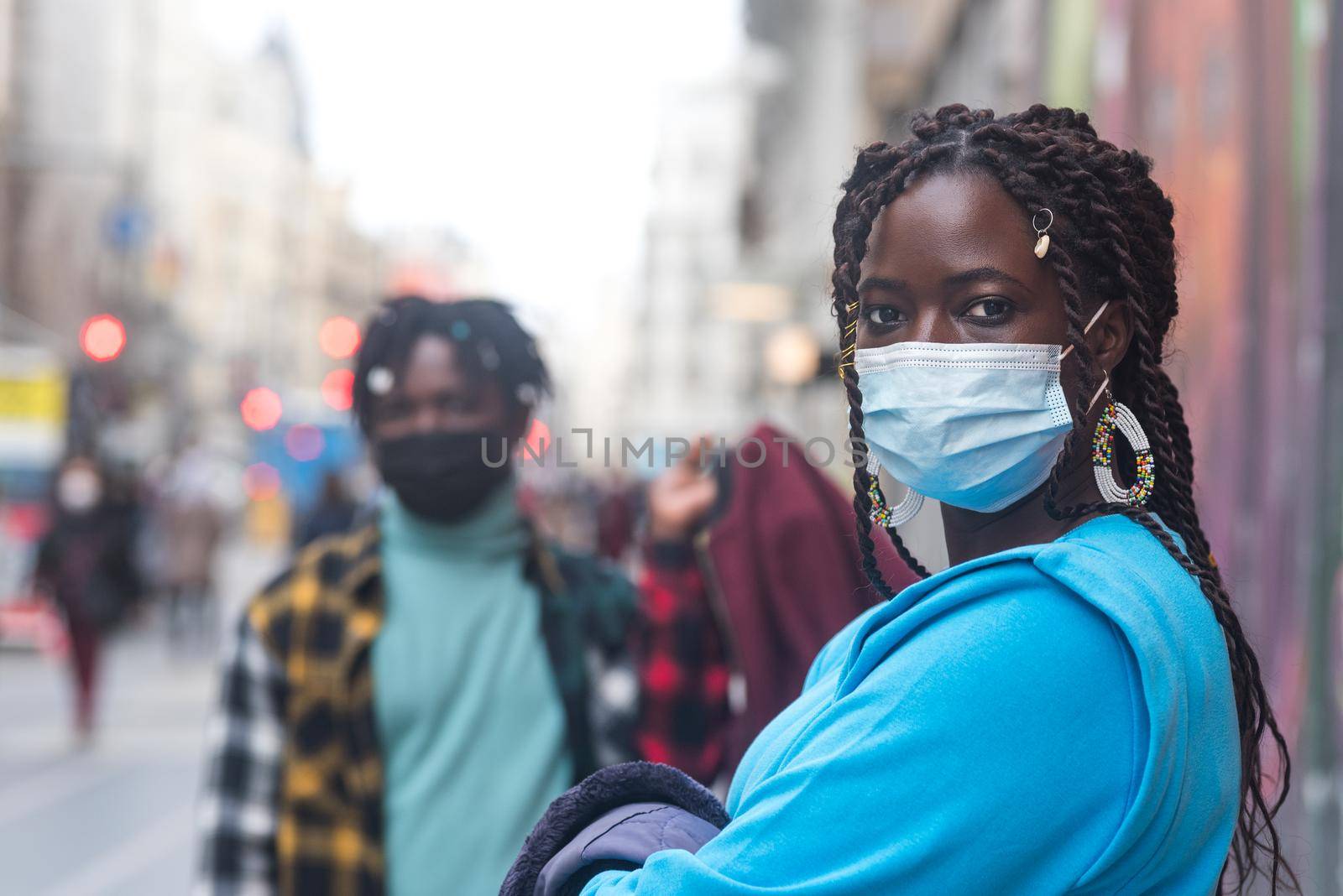 Black couple in the city. With masks. Selective focus.