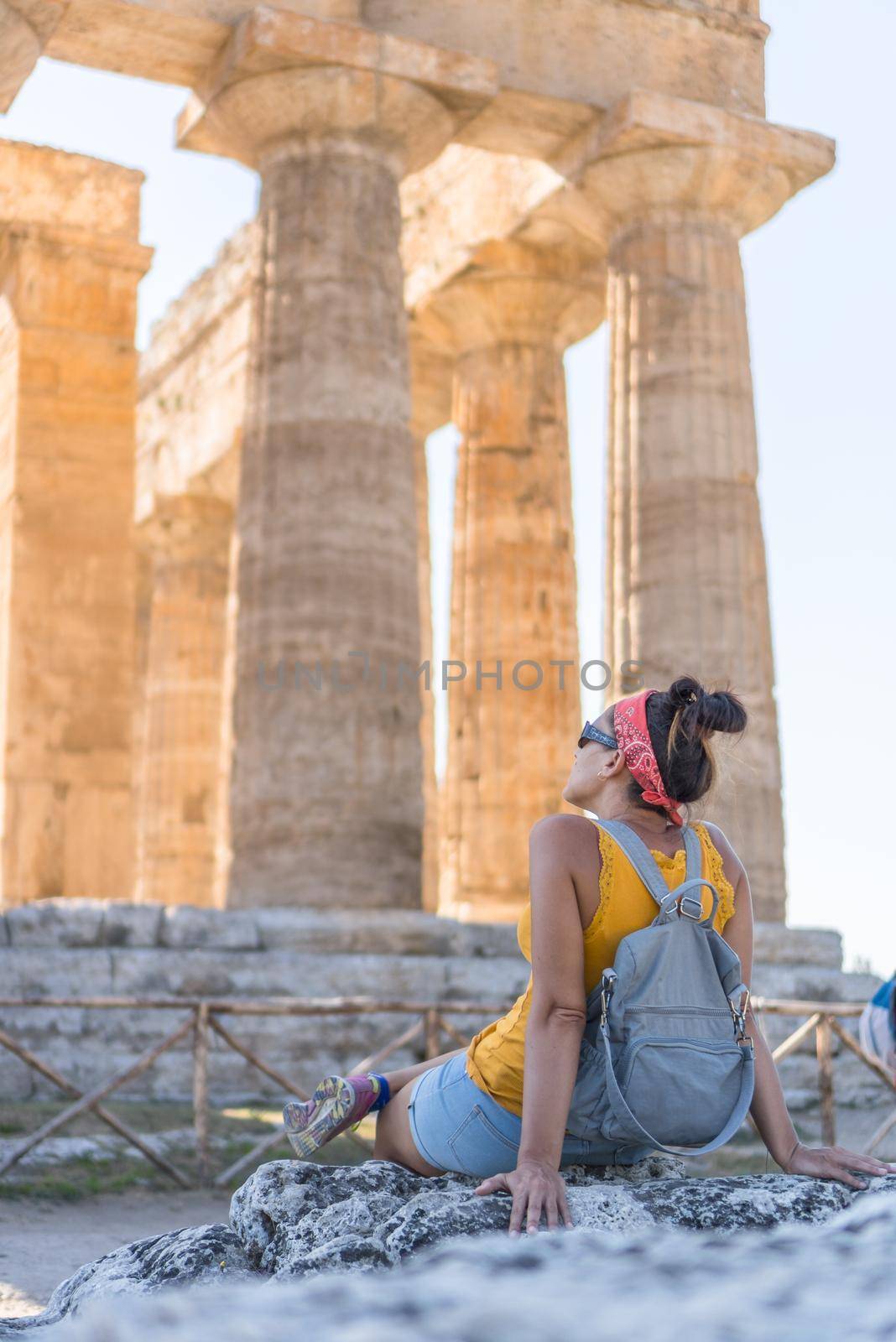 Woman contemplating a temple at the greco-roman archaeological site of Paestum, Italy.