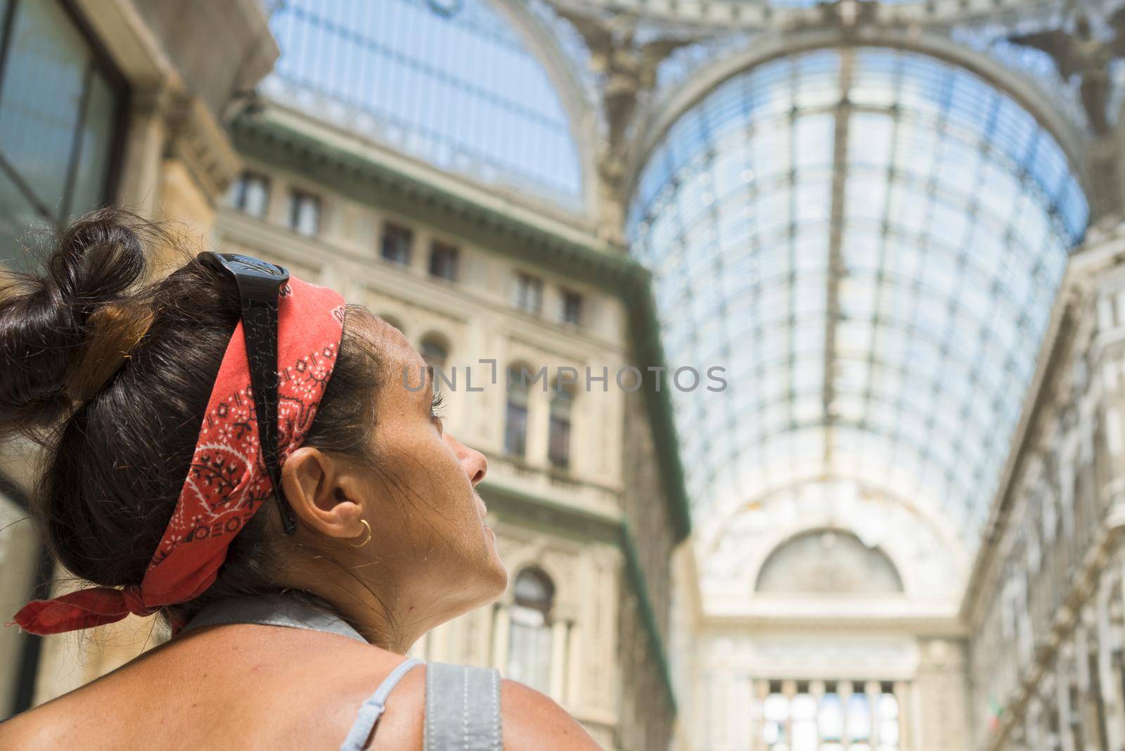 Woman with hair pulled back to the camera looking at the Umberto I gallery of Naples. Italy