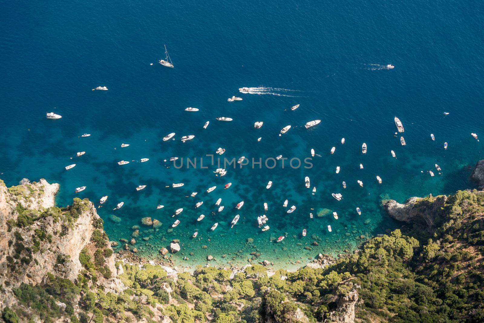 View from the top of many small boats in the sea, on a beautiful sunny summer day. Capri island.