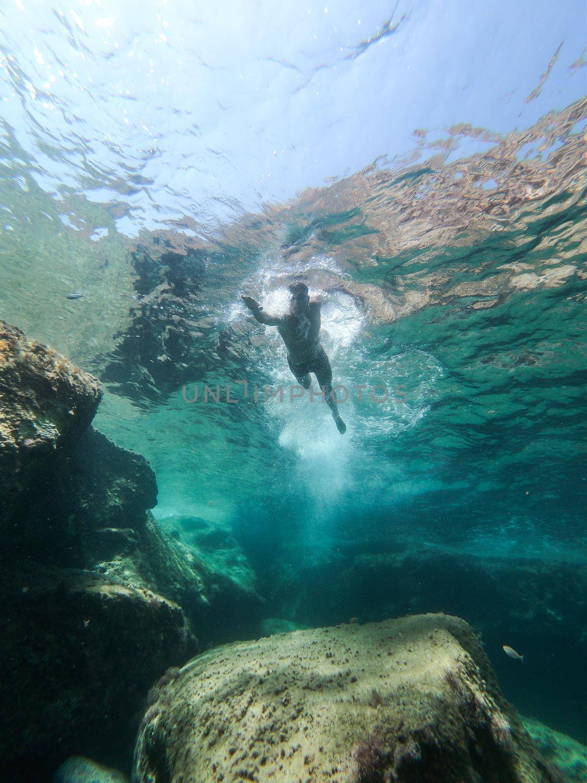 Man swimming in the sea. View from inside the water.