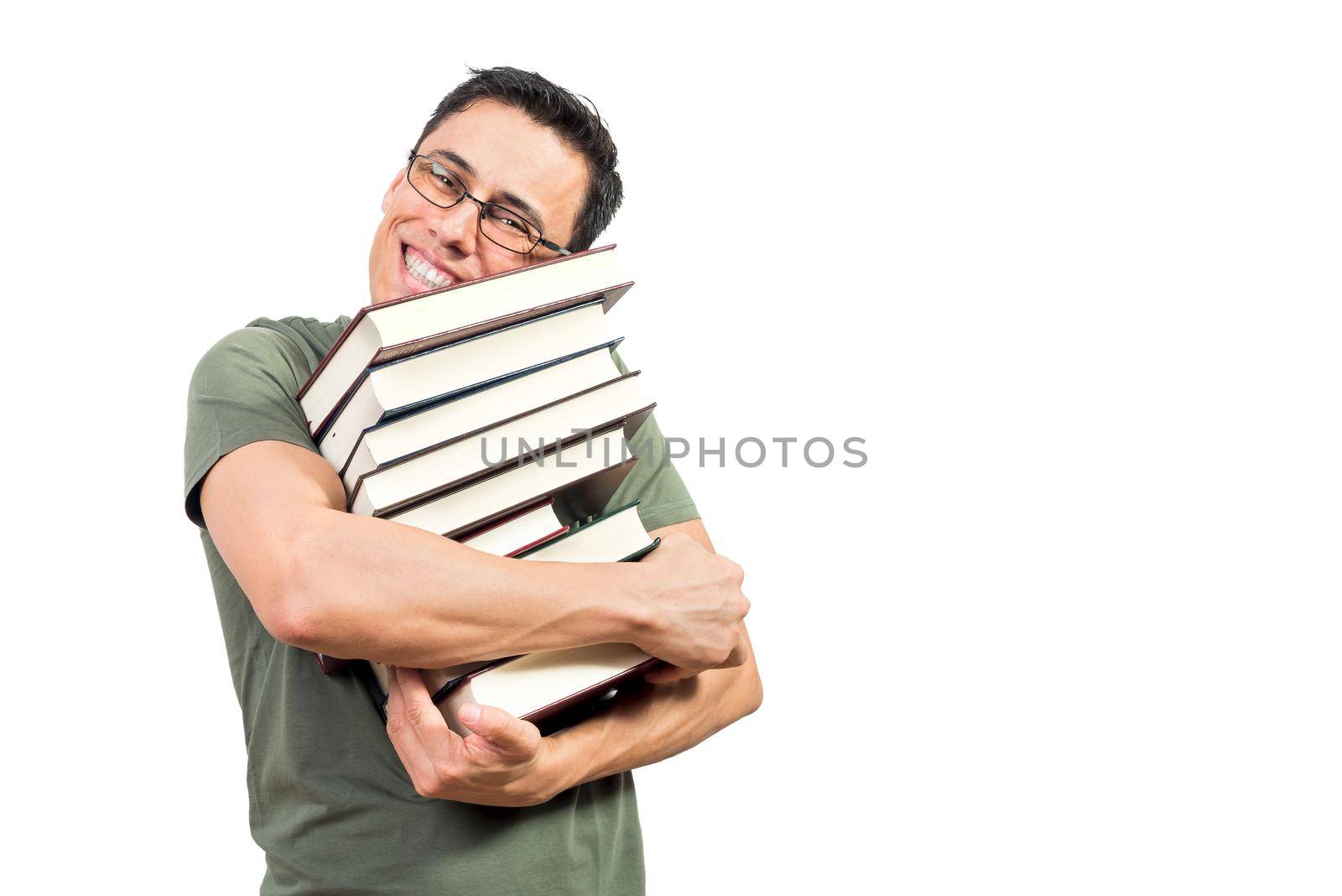 Merry man in green t shirt and glasses hugging pile of good books and looking at camera with toothy smile against white background